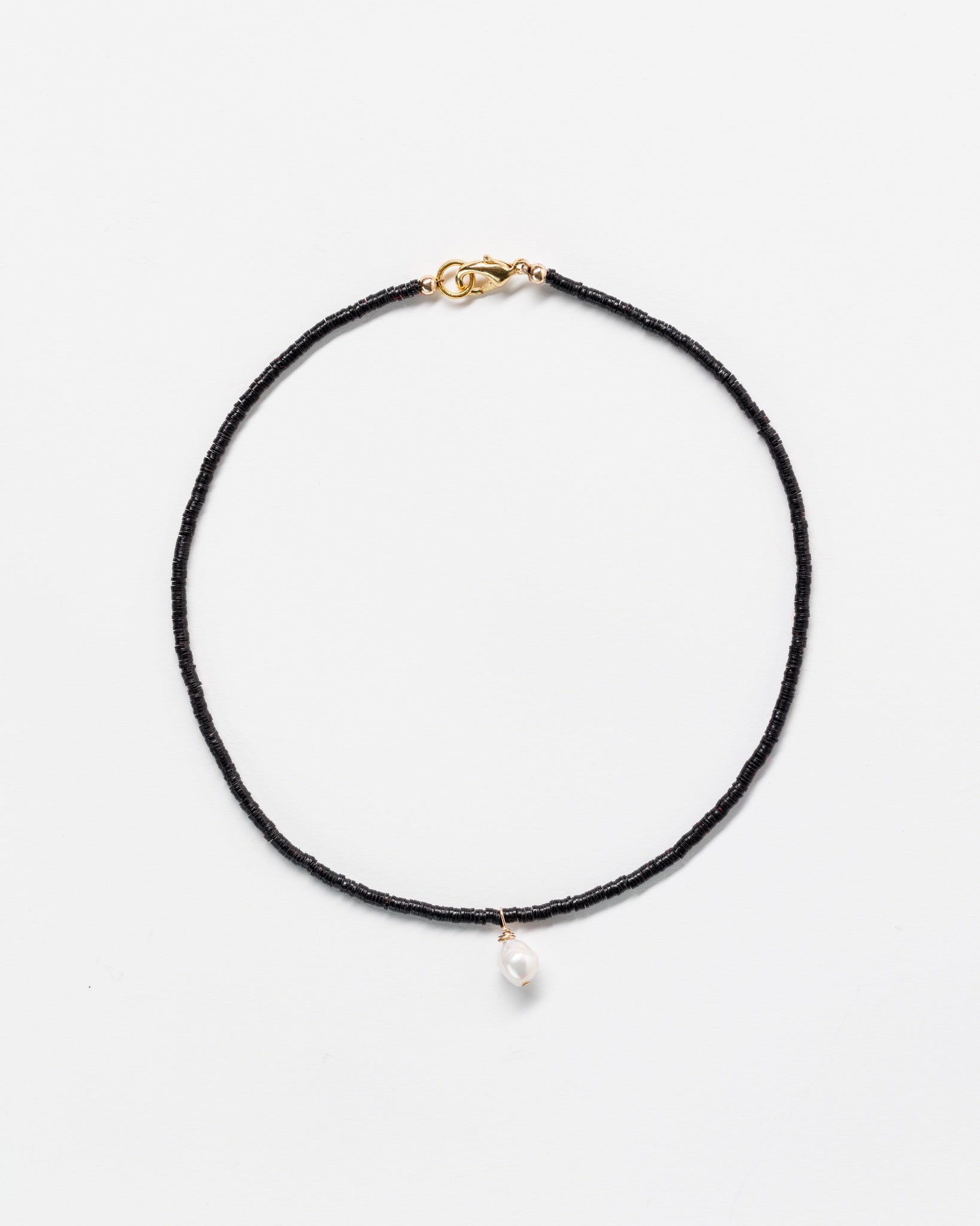 A delicate multi color Designs By Raya necklace with a single small pearl pendant, featuring a golden clasp in Arizona style, displayed on a plain white background.