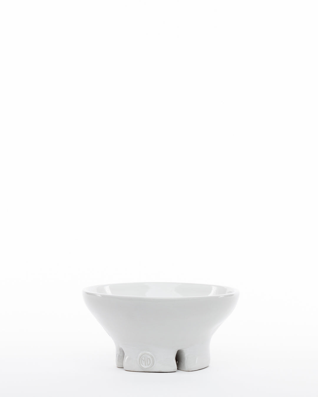 A simple white ceramic bowl with a unique design, featuring three small feet at its base, set against a plain white background in a Scottsdale Arizona bungalow - the Montes Doggett Catchall Bowl No. 257.