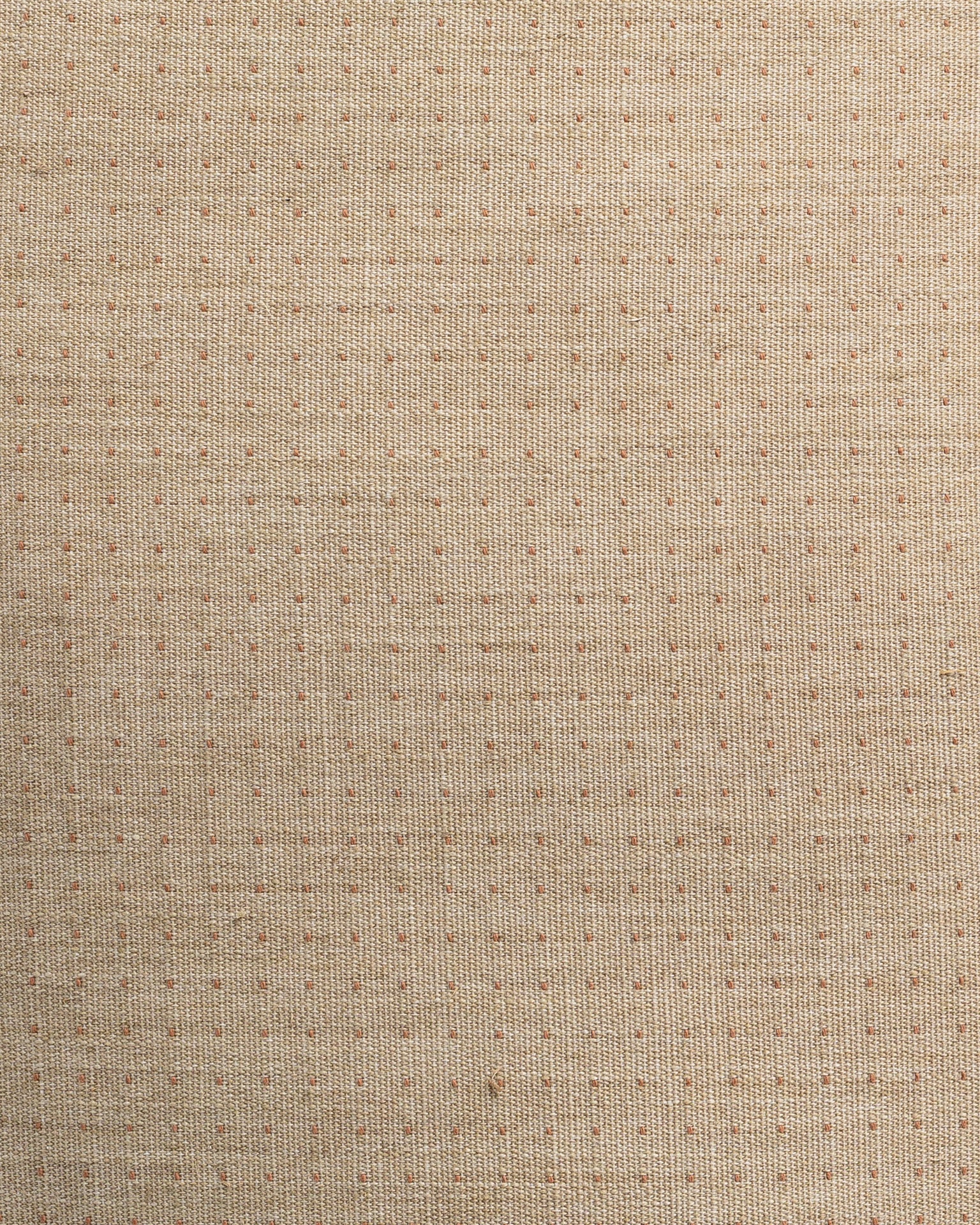 Close-up texture of a beige fabric with a subtle, uniform pattern of tiny, scattered red dots, reminiscent of the rustic interiors found in Scottsdale Arizona bungalows can be seen on the Gabby Happy Dot Blush Pillow 26x26.