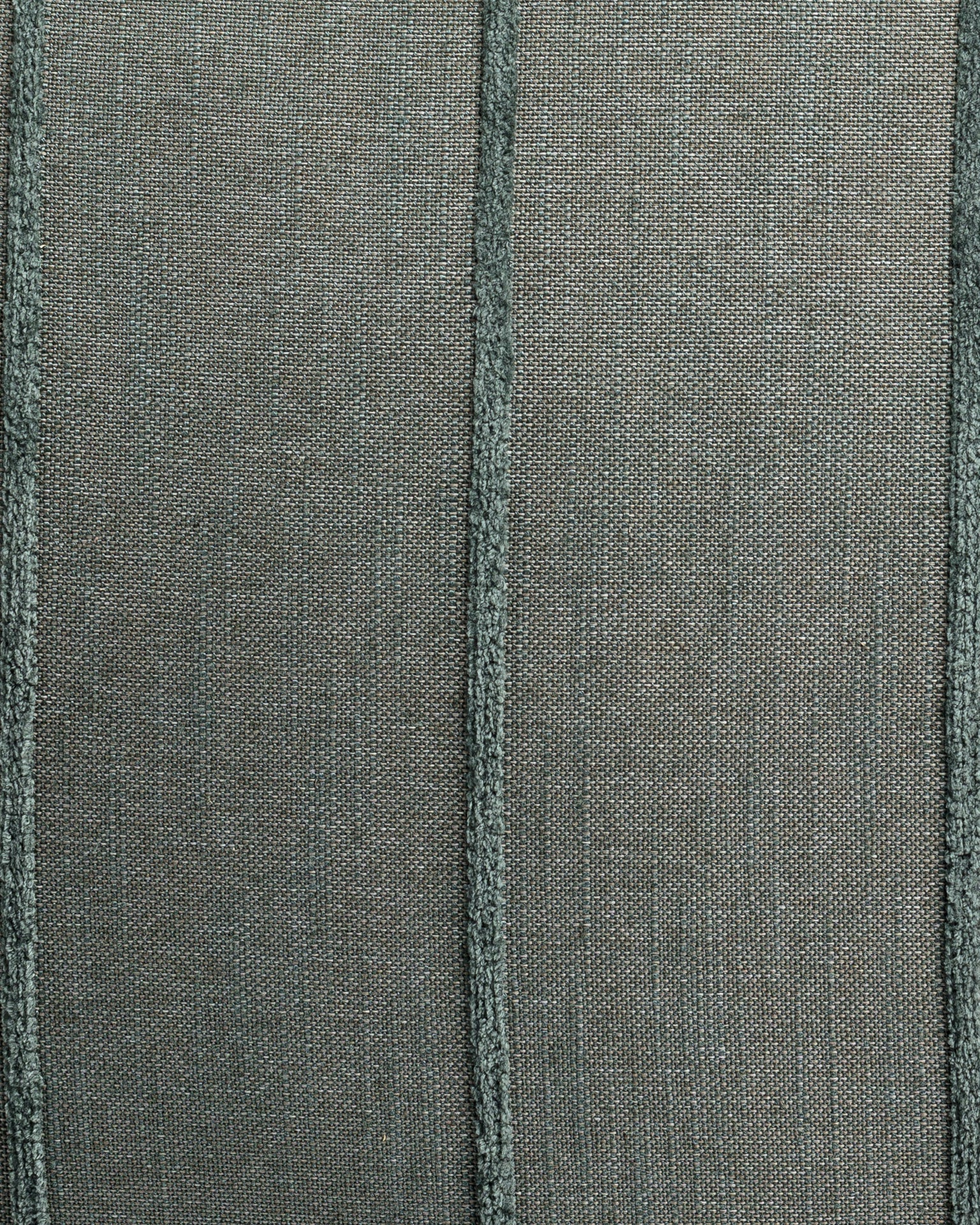 The Hilo Stripe Blue Spruce Gr-3 Pillow by Gabby features a textured green fabric with vertical seams, creating a woven pattern that enhances depth. This custom-made pillow insert adds structure and style to any chic bungalow setting.