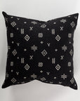 The Custom 1 Pillow 28x28 by Pindler is a luxurious black euro pillow adorned with intricate white geometric and tribal patterns, including diamond shapes and cross-like symbols, providing a striking contrast against its dark background.