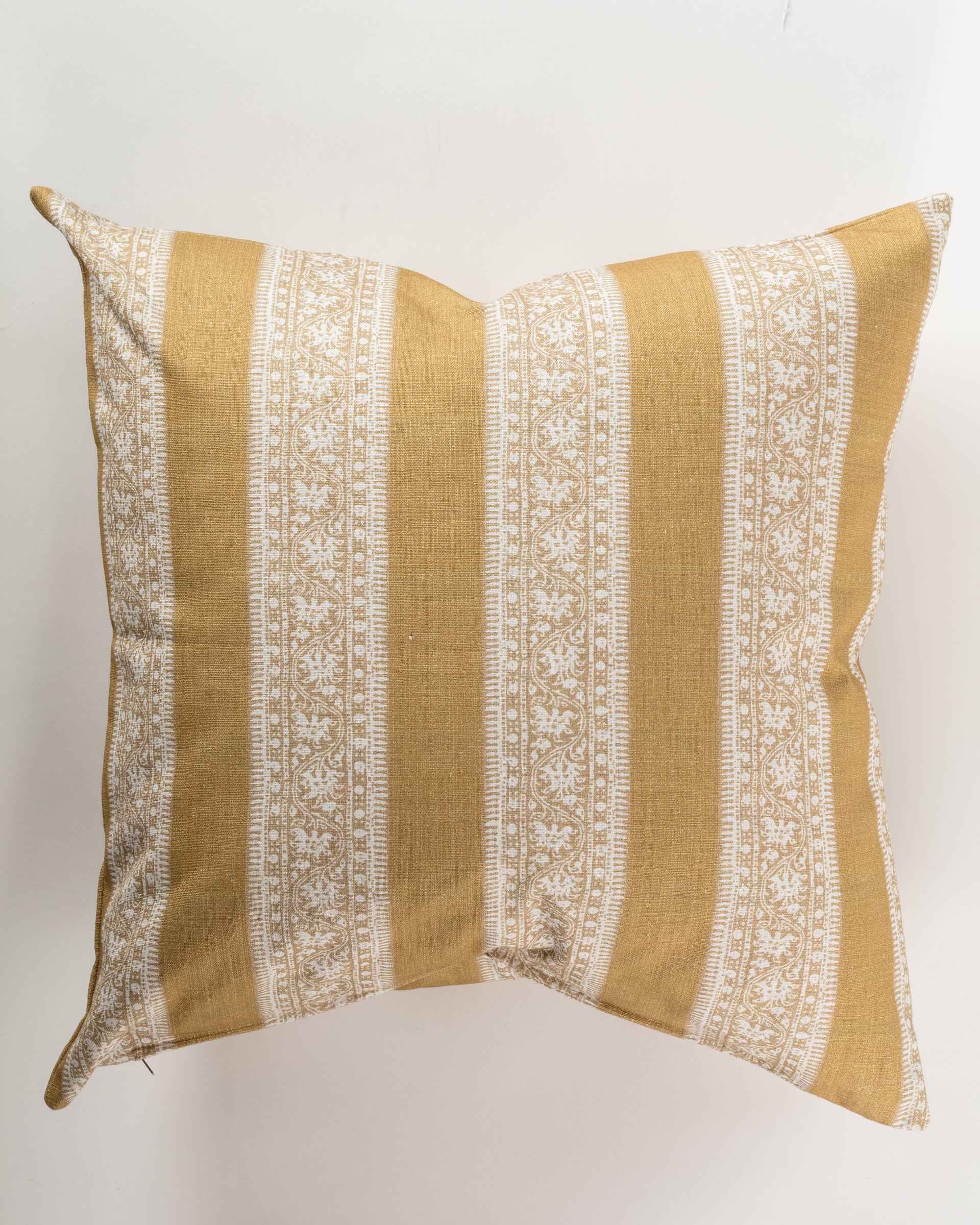 The Pindler Custom 4 Pillow 28x28 features a mustard yellow base adorned with intricate white floral patterns and vertical stripes, offering extra comfort. Its symmetrical design is ideal for layering on a light, smooth background.