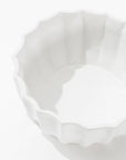 Montes Doggett’s Bowl No. 131, a white high-fired ceramic bowl with a scalloped, wavy edge, is photographed empty against a plain white background with soft shadows inside and around it.