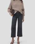 Black wide-leg jeans, funnel neck top, and heeled sandals styled with a brown clutch; modern fall outfit by CLOSED.
