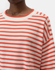 A person models the CLOSED Striped Crew Neck, a cream and orange fine-knit sweater with a round neckline, shown from shoulders to just above the mouth against a plain white background.