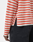 A person wearing a CLOSED Striped Crew Neck sweater with red and white stripes and side slit, paired with black jeans; only their torso and upper legs are visible.