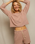 A smiling woman with blonde hair wears the Perfectwhitetee Cami Terry Stripe LS, a slouchy red-and-white striped set, standing in front of a light background with her arms raised above her head.