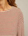 Close-up of the Perfectwhitetee Cami Terry Stripe LS: a slouchy, cream long sleeve with red and black horizontal stripes. Soft plush loop terry texture is highlighted near the neck, shoulder, and hair for a cozy look.