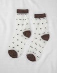Unified Sheer Dot Socks—sheer anklets with small black polka dots and solid brown heels, toes, and cuffs—are perfect for adding playful flair to women's fashion accessories.