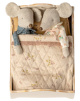 Two fabric mouse dolls with sewn clothes lie snugly side by side under patterned bedlinen in a Maileg Bed by Maileg, looking cozy together.