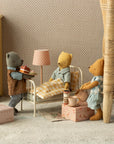 Maileg Mini Hot Chocolate Set in pink boxes with three stuffed bears sharing gifts in a cozy dollhouse bedroom setting.