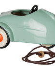 Green vintage-style metal toy car with white wheels and brown pull string by Maileg.