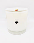 The Fritz & Troy Wild Child Candle is a white coconut/soy wax candle in a glass jar with a wooden wick and a single black star on the front, shown against a plain white background.