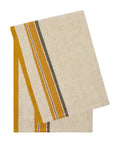 A set of two Antibes Natural Towels by Caravan, featuring beige linen with mustard yellow and dark brown stripes near one edge, neatly folded on a white background.