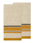 Two folded Antibes Natural Towels Set-2 by Caravan, made of beige linen cotton with horizontal mustard yellow and dark gray stripes near one edge, are placed side by side on a white background.