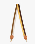 The Clare Vivier Adjustable Crossbody Strap features a cotton webbing with beige, brown, and yellow stripes, tan leather ends, and gold metal clasps.