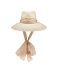 The Tatum Extra Long Brim Hat by Ninakuru features a wide Toquilla straw brim, beige ribbon detail, and extended scarf-like ties, beautifully set against a white background.