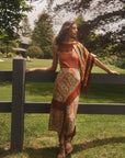 Hunter Bell NYC Allyne Skirt in a sunlit yard, styled casually by a wooden fence for a relaxed outdoor look.