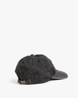 The Clare Vivier Denim Baseball Hat is shown from the back in dark gray cotton denim, featuring visible stitching, a metal buckle adjustable strap, and a one-size-fits-most design. The cap is displayed on a plain white background.
