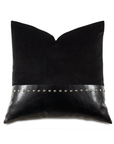 A Nail Licorice Pillow from Eastern Accents, adorned with a silver-studded leather band across the center, creates a stylish bungalow-style decorative accessory on a white background.