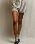 A person stands against a neutral backdrop, wearing Perfectwhitetee French Terry Shorts with an elastic waistband, light-colored socks, and brown shoes. Only the lower half of their body is visible.