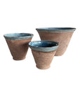The Blue Ocean Traders Cottage V-Bowl set features three terracotta pots of different sizes with a glossy blue interior and rim, combining handmade pottery charm and elegant design, displayed on a white background.