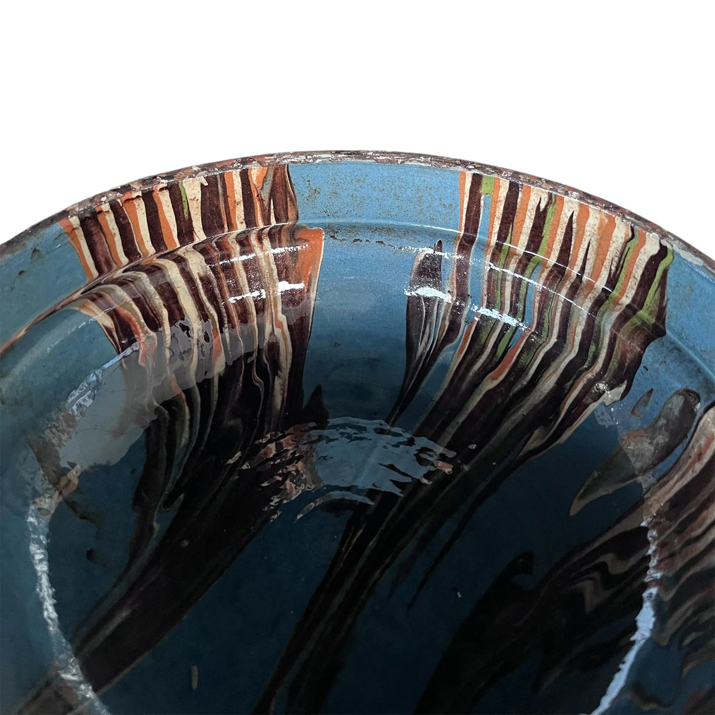 Close-up of the Cottage Crafted Bowl by Blue Ocean Traders, featuring a blue glaze and streaked brown, cream, and white patterns on the rim and interior, with a glossy finish perfect for decorative displays.