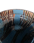 Close-up of the Cottage Crafted Bowl by Blue Ocean Traders, featuring a blue glaze and streaked brown, cream, and white patterns on the rim and interior, with a glossy finish perfect for decorative displays.