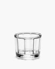 The Surface Glassware by Serax is a small, clear glass bowl with vertical ridge patterns, shown on a plain white background and reflecting contemporary designer elegance.