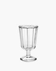 The Serax Surface Glassware is a clear, vintage-style designer goblet with vertical ridges and a short stem, showcased against a plain white background.