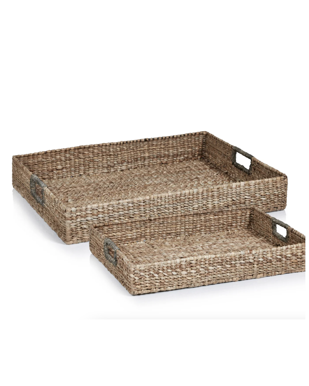 Two rectangular woven Zodax seagrass trays with side cut-out handles, stacked on top of each other, against a white background, perfect for a bungalow in Scottsdale Arizona.