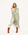Imperfect Heart cotton-knit poncho with drippy heart design by Kerri Rosenthal, styled with boots and sunglasses.