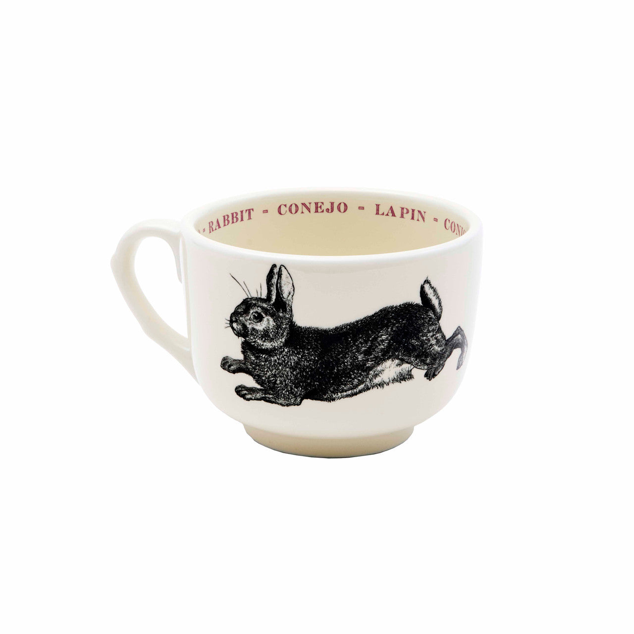 The Sir/Madam Grand Cup is a white ceramic mug featuring a black rabbit illustration. The inner rim displays the animal's name in four languages, repeated in vibrant colors for a global flair.