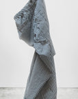 The Indigo Stripe Sailor Pant by Free City (sparrow, LLC) stands upright, partially folded with bent legs and uneven sides, set against a plain white background and concrete floor.