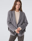 KUJTEN G3 fringe blazer over cream sweater and dark jeans, styled against a neutral background.