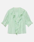 The DOEN Henri Top is a light green organic cotton blouse with short puff sleeves, ruffled neckline and front, gathered sleeve details, and a flowy lightweight fabric for a feminine Edwardian-inspired look.