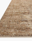 A close-up image of a Bark / Multi Rug from Loloi Rugs with a subtle, distressed pattern in shades of brown and beige, viewed from a low angle to highlight its thin profile and Bungalow style.