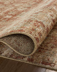 Close-up of a partially rolled, textured Loloi Rugs Brick / Multi Rug displaying earthy tones and intricate patterns on a wooden floor in a Scottsdale Arizona bungalow.