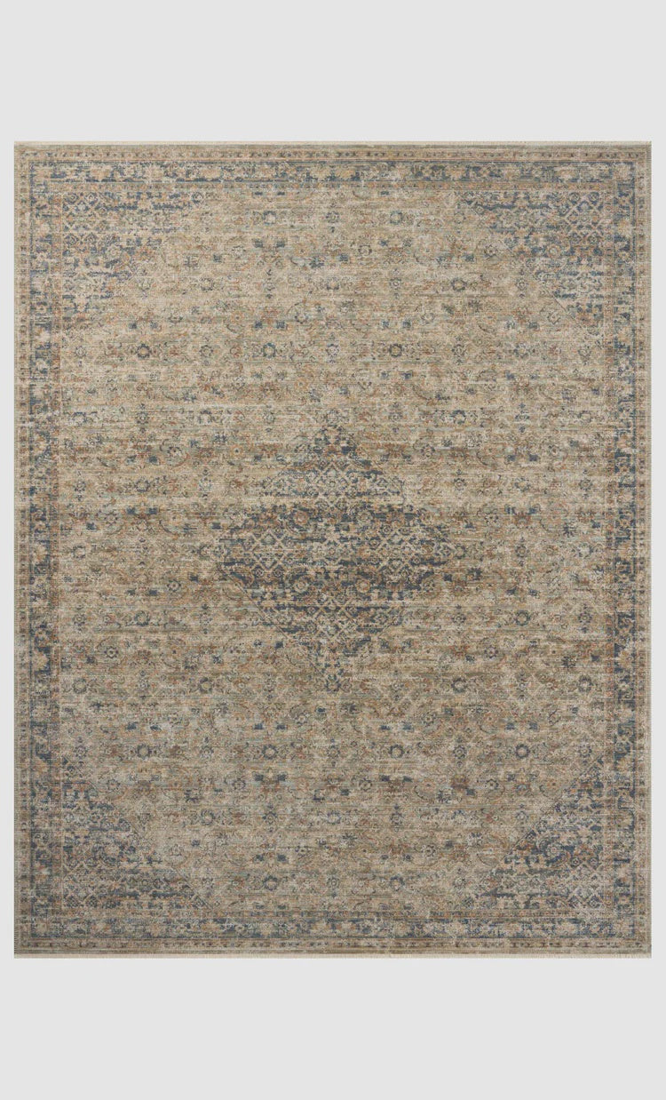 A detailed, vintage-style Sage / Navy Rug in muted beige, blue, and gray tones featuring intricate traditional patterns typical of Scottsdale, Arizona, with a distressed finish. The Loloi Rugs's edges are bounded, accentuating its rectangular shape.