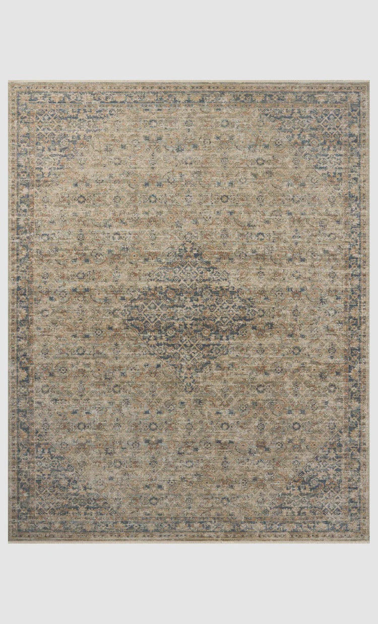 A detailed, vintage-style Sage / Navy Rug in muted beige, blue, and gray tones featuring intricate traditional patterns typical of Scottsdale, Arizona, with a distressed finish. The Loloi Rugs&#39;s edges are bounded, accentuating its rectangular shape.
