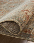 Close-up of a rolled corner of an ornate, multicolored Loloi Rugs Grey / Sunset Rug in a Scottsdale bungalow, showcasing its texture and intricate pattern.