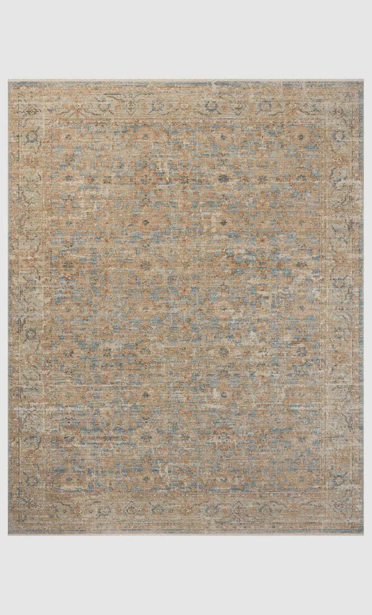 A textured Ocean / Sand Rug displaying a faded, intricate pattern with shades of blue, beige, and brown, resembling a vintage style typical of a Scottsdale Arizona bungalow by Loloi Rugs.