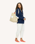 Kerri Rosenthal KR Imperfect Heart Hobo Tote carried by woman in blue cardigan and white pants, with red flats.