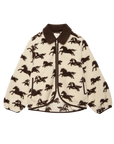 The Pasture Jacket by The Great Inc. is a cream sherpa teddy jacket with a brown collar, all-over galloping horse motif, front zipper, relaxed fit, and elastic cuffs.