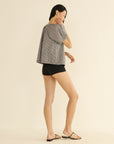 DOEN June Top in light fabric and black shorts, modeled sideways against a soft, neutral background.