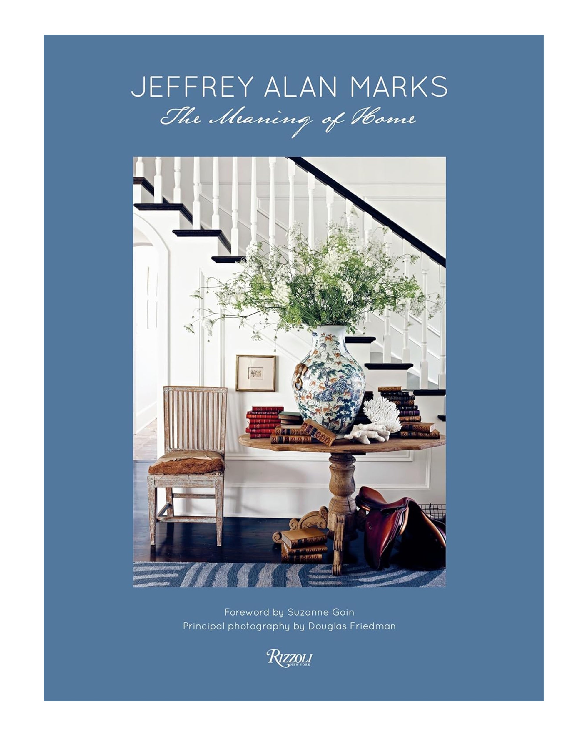 Book cover for "Jeffrey Alan Marks" by Random House, showing a styled entryway with wooden table, blue vase with greenery, chair, books, staircase—interior design framed by a blue border.