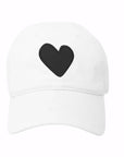 The Embroidered Heart Hat by Kerri Rosenthal is a white cap featuring a bold black embroidered heart on the front, blending classic collegiate style with a modern twist.