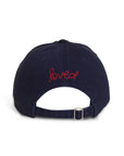 The Kerri Rosenthal Baseball Hat Heart Patch in navy blue is shown from the back, with "love" and a red embroidered heart above the adjustable strap for a fresh take on classic styles.