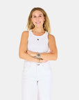 A woman with long blonde hair smiles, arms crossed, wearing the Kerri Rosenthal KR Tank and matching pants against a plain light background. She accessorizes with bracelets and a watch on her left wrist.