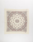 The Hachiko Scarf by BCS Group is a square, cream-colored bandana made from 100% cashmere, featuring a detailed red and blue paisley and floral pattern arranged symmetrically along the border and center.